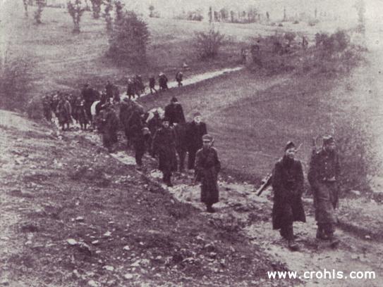Delegacije Slovenije i Hrvatske na putu u Jajce . Kolona partizana i partizanskih dužnosnika iz Slovenije i Hrvatske na putu na 2. zasjedanje AVNOJ-a u Jajcu. Na čelu razvučene, neuredne povorke nalaze se partizani s rukama u džepovima i puškama prebačenima preko oba ramena. Partizani su još daleko od uređene vojske.