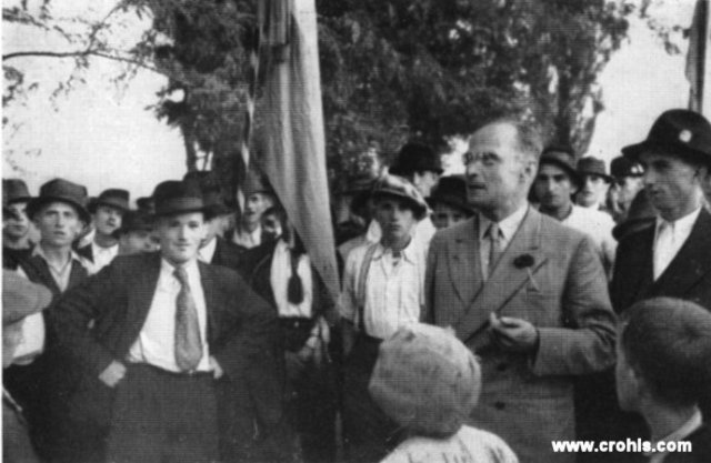 Dr. Juraj Krnjević u selu Treščerovcu. Premda se HSS nastoji nastupati kao seljačka stranka u stvarnosti vodstvo stranke se čvrsto nalazi u rukama obrazovanog građanstva. To lijepo ilustrira ova fotografija po zadnjoj modi odjevenog istaknutog vođe HSS-a Jurja Krnjevića sa skromno odjevenim, seljačkim biračkim tijelom. 