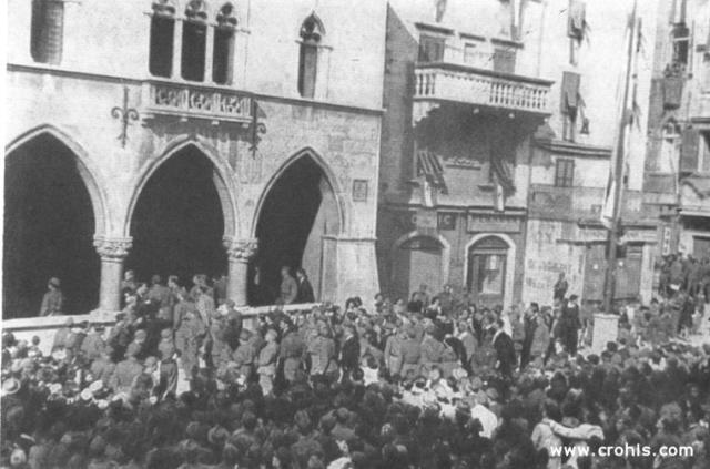 Delegati ulaze u vijećnicu. Delegati ulaze u zgradu stare splitske gradske vijećnice u kojoj će biti proglašena vlada Hrvatske. Delegati koji ulaze u vijećnicu u pravilu su uniformirani. Njihove vojničke odore pokazuje gdje se nalazi podrijetlo nove vlasti.